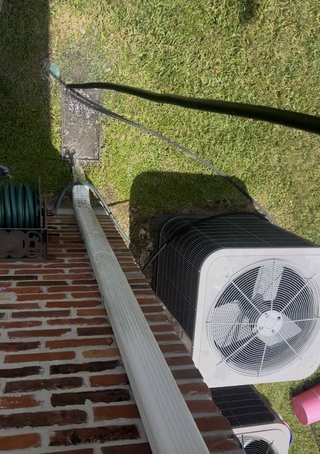 Downspout flush test showing water running clear
